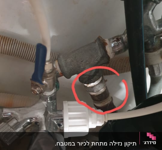 צינורות מתכת וחיבורים מתחת לכיור